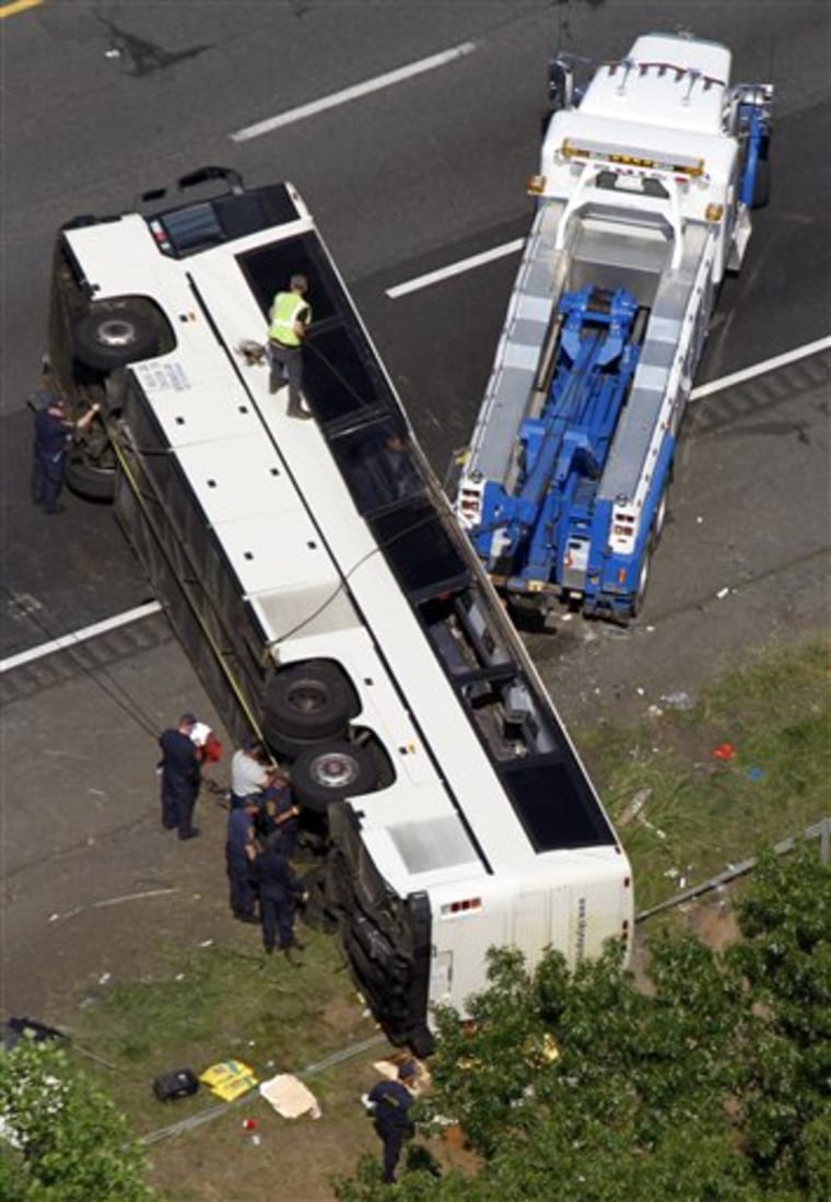 Rescue personnel work on a bus that overturned Tuesday, May 31, 2011, in Bowling Green, Va. The commercial tour bus went off Interstate 95 in Virginia and flipped on its roof before dawn Tuesday, killing four people and injuring many more, state police said. (AP Photo/Steve Helber)